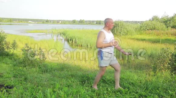 一位中年男子早上在湖边做瑜伽和呼吸练习视频的预览图
