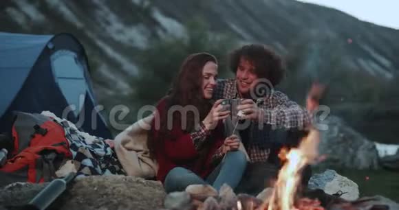 美丽的捕捉一对夫妇度过了一个浪漫的夜晚在山中间的篝火和视频的预览图