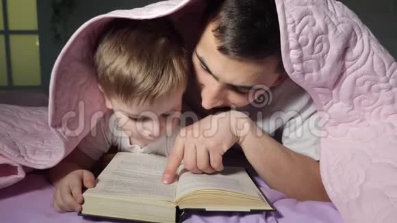 爸爸教他的小儿子读一本藏在毯子下面的书视频的预览图
