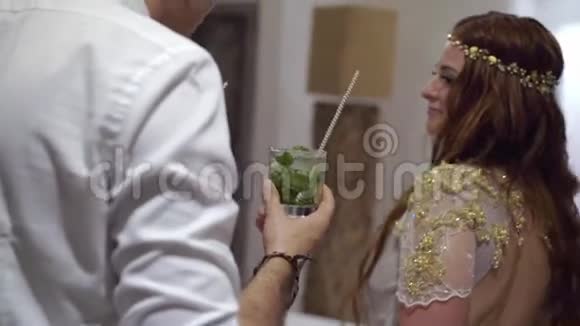 一个年轻女孩和一个男人在聚会上喝鸡尾酒视频的预览图