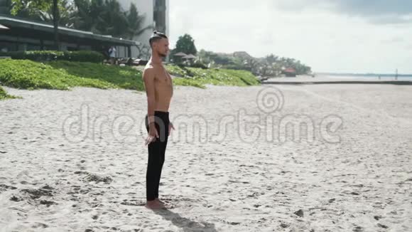 运动员在沙滩上做瑜伽双手并拢双眼紧闭慢动作稳定射击视频的预览图