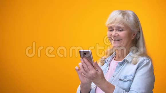 快乐的老太太在智能手机在线医疗服务购物上滚动视频的预览图