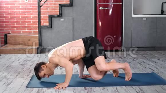 积极健身男性练习瑜伽运动在垫子上家庭厨房全镜头视频的预览图