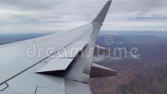 云层覆盖山脉从飞机窗口俯瞰空中景色视频的预览图