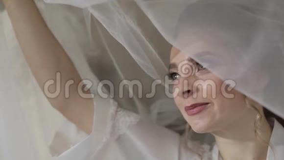 美丽可爱的新娘穿着长袍戴着巨大的面纱婚礼早视频的预览图