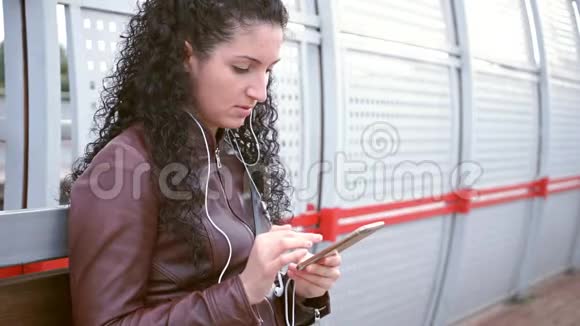 女孩坐在车站写短信视频的预览图