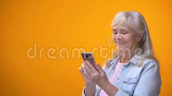 微笑的老年女士在智能手机上打字退休人员的现代技术素养视频的预览图