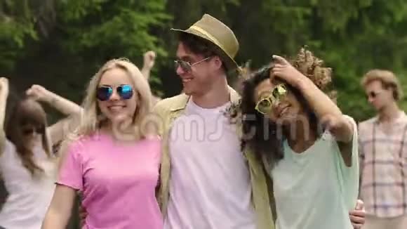 快乐的年轻人在户外聚会上和两个美女跳舞夏天调情视频的预览图