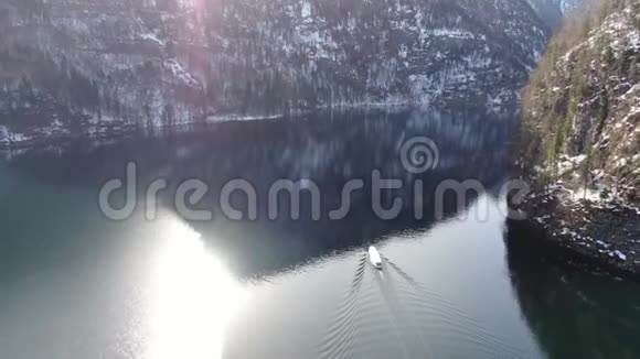 太阳反射在山湖上一艘船正在航行空中拍摄4k视频的预览图