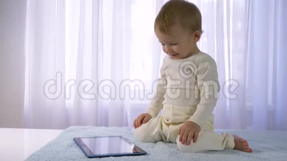 儿童发展的现代技术美好快乐的婴儿在明亮的房间里玩平板电脑视频的预览图