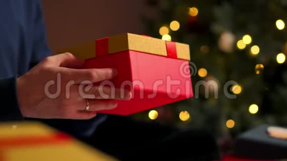 特写男送礼物年轻漂亮的夫妇戴着圣诞帽穿着舒适的毛衣微笑着互相祝贺视频的预览图