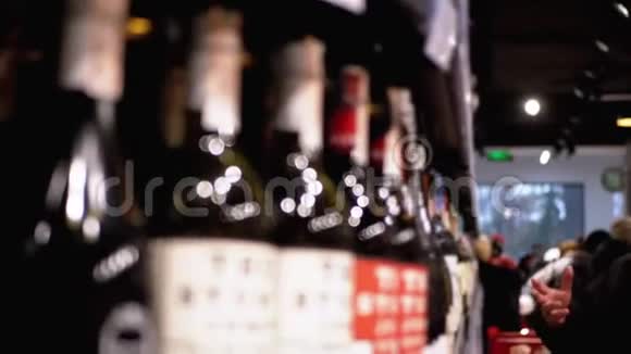 超市卖酒布卢尔商店橱窗上印有价格标签的瓶装葡萄酒的架子和架子视频的预览图