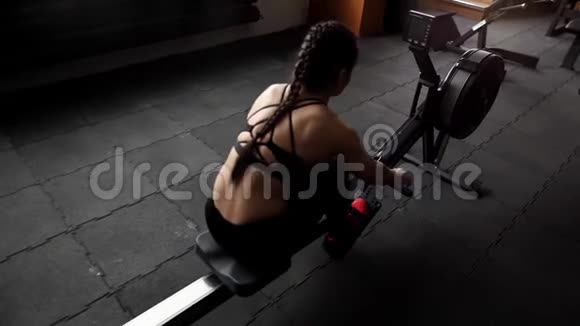 年轻女性运动员在健身房用动力模拟器进行慢动作锻炼视频的预览图