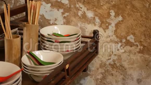 带有东方餐具的架子木制架子有各种亚洲餐具挂在厨房破壁附近视频的预览图