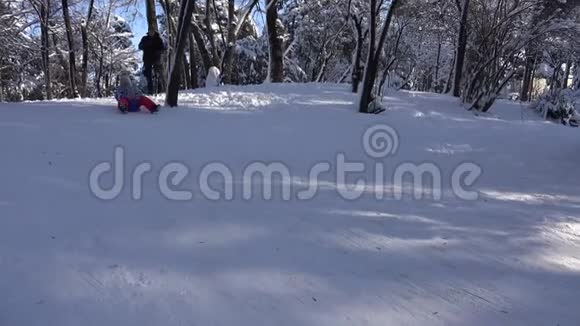 儿童在雪中雪橇小女孩在冬天玩耍儿童在公园滑雪视频的预览图