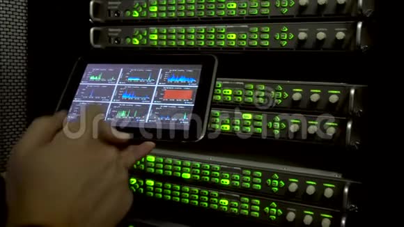 IT工程师用一台平板电脑测量网络速度发光二极管闪烁在后台服务器机架上在t中有振动视频的预览图