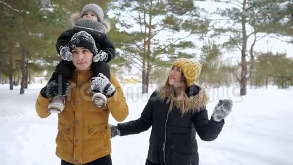 幸福的年轻一家人一起在冬季城市公园散步视频的预览图