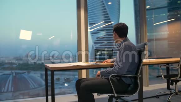 西班牙裔企业家男性商务办公室里坐在扶手椅上手里拿着笔记本电脑视频的预览图