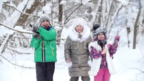 冬季森林快乐的孩子们穿着鲜艳的衣服吹圣诞饼干视频的预览图