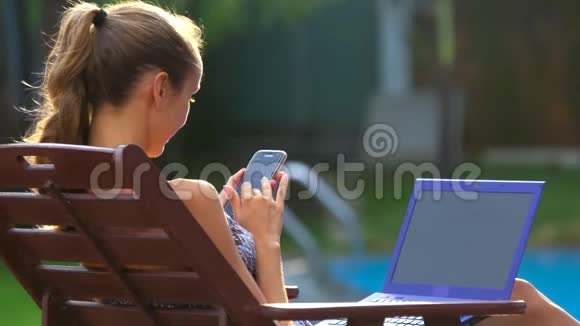 坐在泳池旁的椅子上打电话上网的女孩视频的预览图