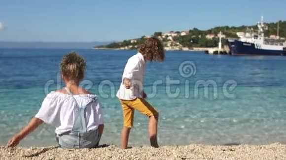 后景学童卷曲的男孩和女孩在地中海海岸互相玩耍亚得里亚视频的预览图