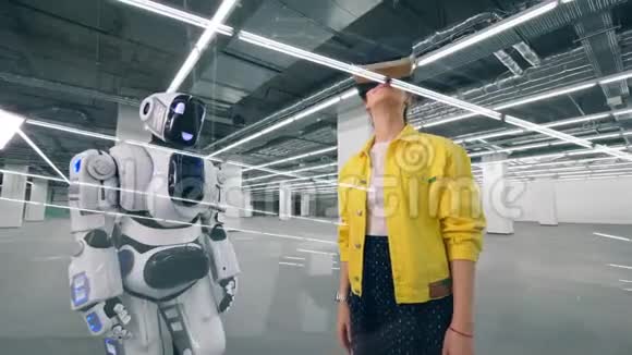 像人一样的机器人正在触摸一个戴着VR眼镜的女人的手视频的预览图