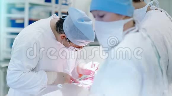 专注的外科医生进行重要的手术看病人在桌子上拿着仪器视频的预览图