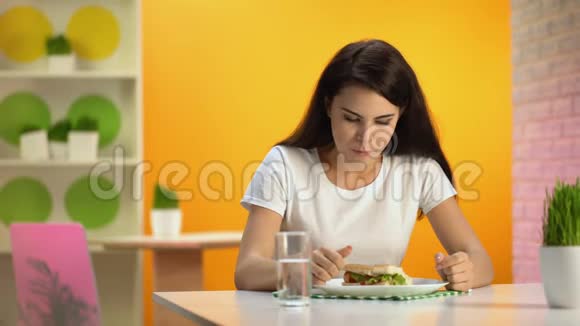 女性恶心坐在食堂桌上垃圾餐中毒食物质量视频的预览图
