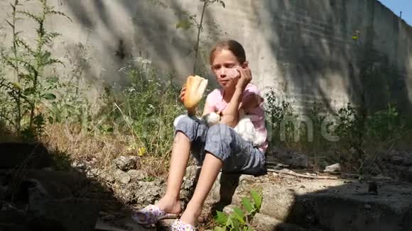 无家可归的悲伤儿童在被遗弃的房子不快乐的流浪女孩吃面包香肠4K视频的预览图