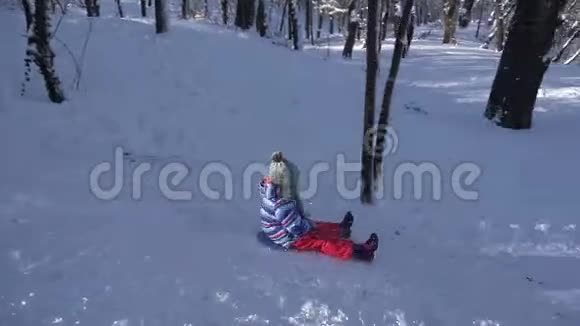 儿童在雪中雪橇小女孩在冬天玩耍儿童在公园滑雪视频的预览图
