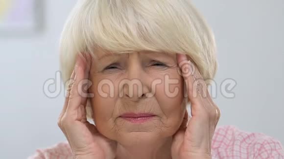 老年女性按摩太阳穴偏头痛健康问题视频的预览图