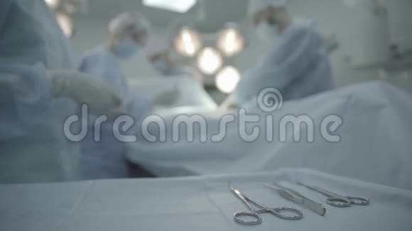 年轻的外科医生在手术室做医疗手术桌子上的工具视频的预览图