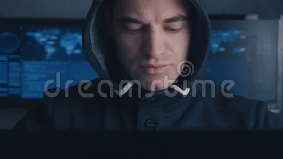 通缉犯黑客在黑暗的办公室里用电脑工作视频的预览图