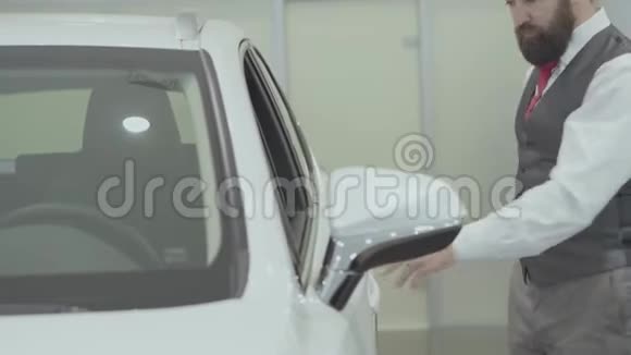 画像上有魅力自信长胡子的商人坐在车里检查从车里买的新车视频的预览图