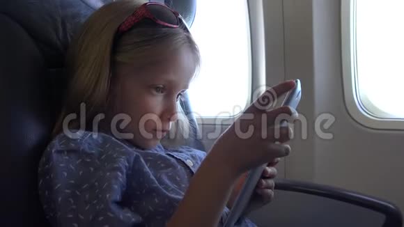 儿童在飞机上玩平板电脑使用智能手机的小女孩肖像视频的预览图
