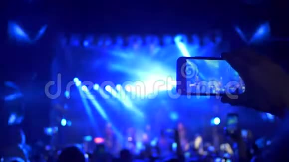 摇滚音乐活动一群拥有智能手机的歌迷手拿着现场娱乐节目并在视频的预览图