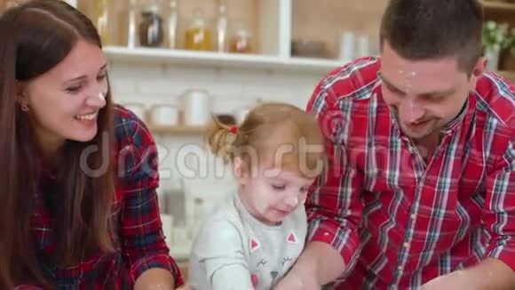 小女孩在厨房里和父母玩得很开心视频的预览图
