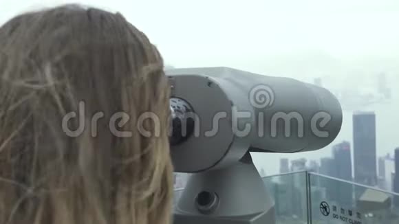 中国香港维多利亚峰上的游客用望远镜观察城市全景旅游妇女视频的预览图