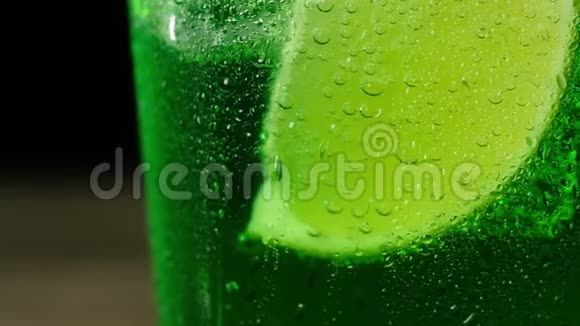 在杯底加一杯绿鸡尾酒的鲜汁青柠片视频的预览图