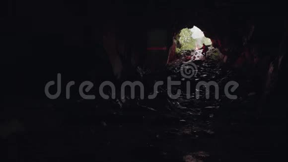 一个人在黑暗而神秘的洞穴里移动手里拿着一个红色的燃烧信号库存录像男性视频的预览图