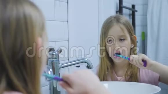 青春期前的女孩刷牙在浴室里洗脸视频的预览图