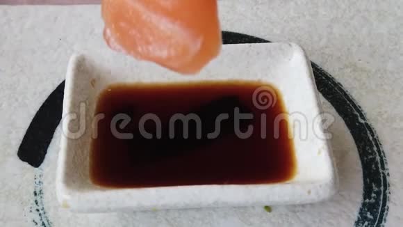酱油碗中的鲑鱼生鱼片和筷子视频的预览图