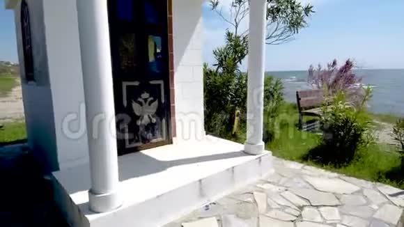 在田园诗般的海滩上的一个小希腊东正教教堂NeaIraklia希腊哈尔基迪基视频的预览图