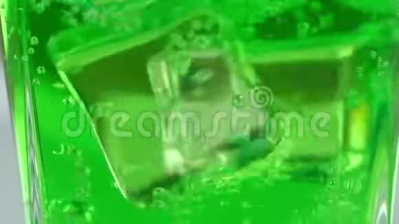 立方冰掉进一个玻璃与绿色碳酸鸡尾酒视频的预览图