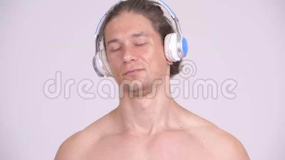 肌肉发达的赤膊男子闭着眼睛听音乐视频的预览图