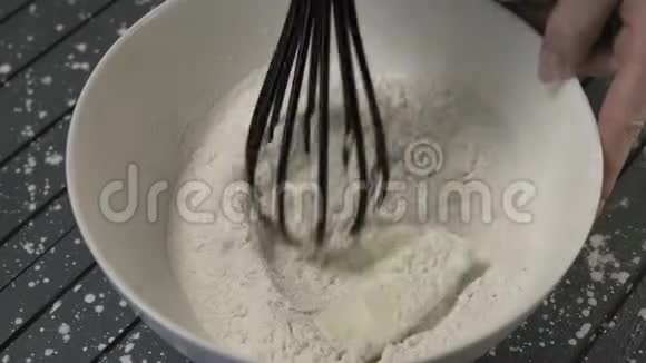 特写女人在白碗中将面粉和黄油混合在一起视频的预览图
