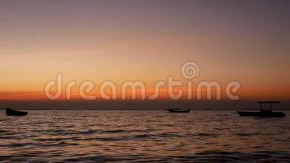 4K日落或日出时小船在海面上随小浪的轮廓美丽的阳光与水面反射视频的预览图
