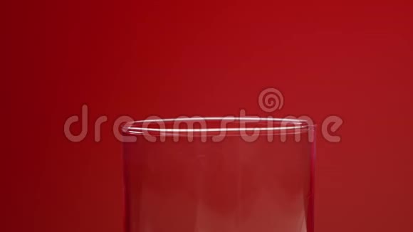 红色苏打水倒在玻璃里红色背景和气泡中心点最小模糊视频的预览图