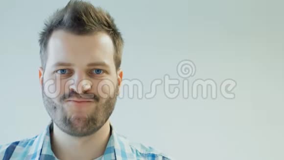 时尚时尚的留胡子男人扭动嘴唇面部表情复制空间视频的预览图