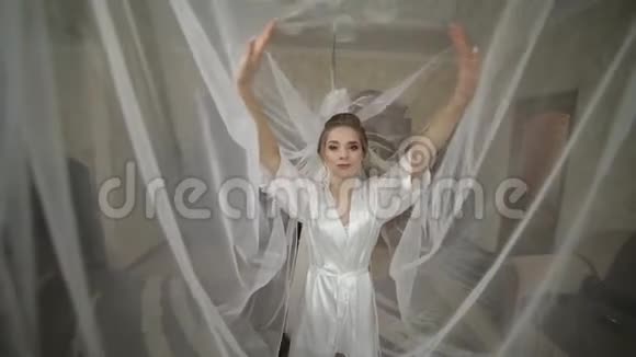美丽可爱的新娘穿着长袍戴着巨大的面纱婚礼早视频的预览图